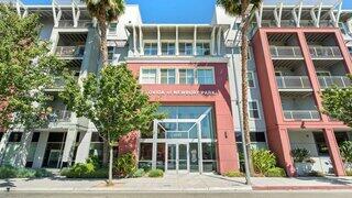 Belovida at Newbury Park Apartments exterior featuring a modern multi-story community with prominent street-facing entrance, balconies, and palm-lined frontage.