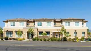 Orchard Ranch features an affordable housing community by EAH Housing with two story residential buildings, landscaped frontage, and neighborhood setting along a tree lined street.