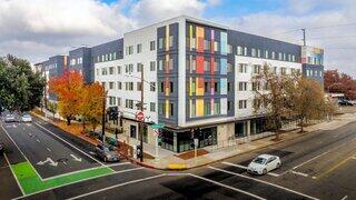 On Broadway features an affordable housing community by EAH Housing with modern multi story design, colorful exterior accents, and street level retail at a prominent urban corner.