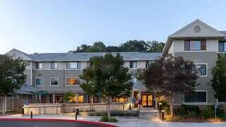 Mackey Terrace features a two story affordable housing community by EAH Housing with light exterior siding, landscaped grounds, and a welcoming covered entry.
