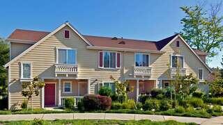 Hamilton Meadows features townhomes community by EAH Housing with beige siding, balconies, and landscaped courtyards in a residential neighborhood