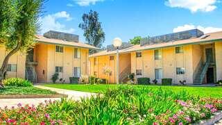 Floral Gardens is a garden style apartment community by EAH Housing with bright landscaping, green lawns, and two story buildings