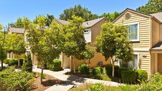 Exterior view of Sonoma Creekside, an EAH Housing community with two-story townhome-style buildings, tree-lined walkways, and landscaped grounds.
