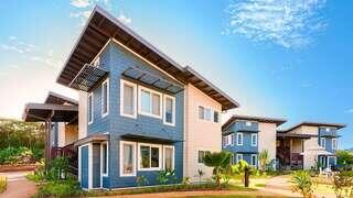 Kolopua features a two story affordable housing community by EAH Housing with modern plantation style design, blue and beige siding, large windows, and landscaped pathways.