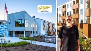 A modern building with a contemporary design, featuring landscaping and an award of merit, alongside a man with a beard and glasses.