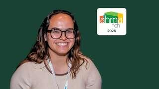 A smiling individual with glasses poses against a green background, alongside a logo featuring "ahma n Ch 2026."