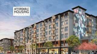 A modern multi-story residential building featuring colorful artwork, surrounded by greenery and shops, promoting affordable housing solutions.