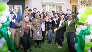 Group of smiling people celebrating after the ribbon cutting of Mission Paradise