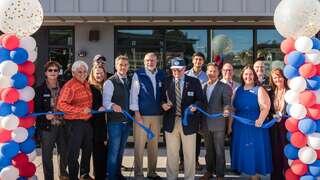 Group of people smiling after ribbon cutting of Lighfighter Village