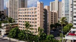 Ainahau Vista II Apartments exterior view of a mid-rise affordable housing community surrounded by palm trees in an urban Honolulu setting.