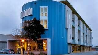 Arbor Lofts exterior highlighting a contemporary multi-story affordable housing community with clean architectural lines and landscaped surroundings.