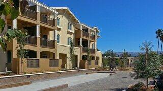 Bella Terra Apartments exterior showcasing a three-story residential community with balconies, stucco facade, and landscaped courtyard.