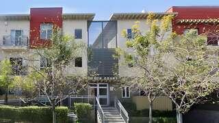 Bronson Court Apartments exterior showcasing a contemporary residential community with bold color accents, central stair entry, and landscaped frontage.