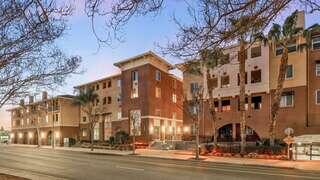 Buena Vista Midtown Apartments exterior featuring a multi-story urban community with warm-toned facade, street frontage, and evening lighting.