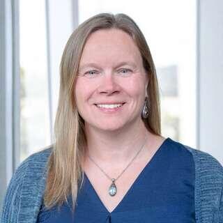 Katherine Fleming, Chief Portfolio Officer at EAH Housing, smiling in a navy top with long blonde hair.