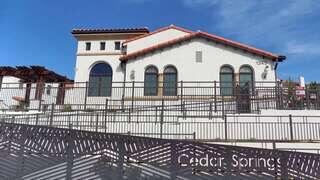 Cedar Springs Apartments, EAH Housing – Single-story community building with a tiled roof, arched windows, and an accessible ramp behind a gated entrance.