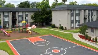 Community Arms Apartments, EAH Housing. Residential complex with playground, basketball court, and open green space in a central courtyard.