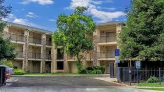 Exterior of EAH Housing community, Village at Kings Canyon, two-storied building courtyard style with balconies and patios.