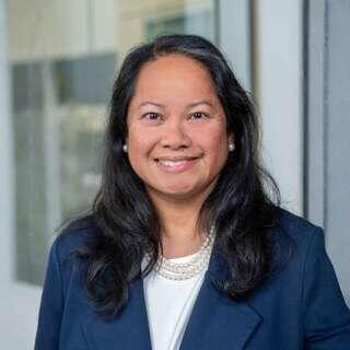 Lissa De Leon, Vice President of Human Resources at EAH Housing, smiling in a navy blazer with a pearl necklace.