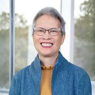 Marianne Lim, Vice President of Portfolio Finance and Policy at EAH Housing, smiling in a blue cardigan with glasses.
