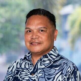 Jon Pasion, Vice President of Real Estate Management at EAH Housing, smiling in a blue and white patterned aloha shirt