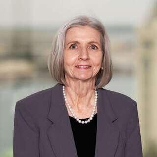 Karen Seddon, Regional Vice President for Hawaiʻi at EAH Housing, smiling in a gray blazer with a pearl necklace.