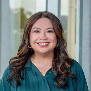 Clarice Veloso-Lugo, Vice President of Communications at EAH Housing, smiling in a teal blouse.