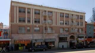 Exterior view of Parkview on the Park, a historic-style multi-story building with retail storefronts at street level and fire escapes above.