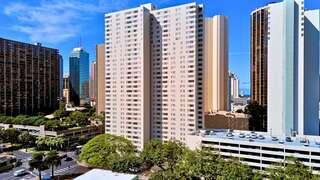 Kukui Tower features a high rise affordable housing community by EAH Housing with a modern exterior, many windows, and surrounding urban skyline in a Honolulu neighborhood