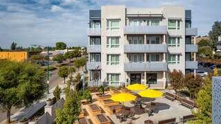 Mission Paradise features a multi story affordable housing community by EAH Housing with landscaped courtyard, covered seating, and welcoming shared spaces.