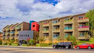 Moonlight Villas features a multi story affordable housing community managed by EAH Housing with solar panels, modern facade, and landscaped streetscape.