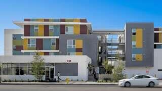 Fullerton Heights features a modern affordable housing comFullerton Heights | Affordable Housing for Families and Special Needs in Fullerton, CAmunity professionally managed by EAH Housing with a colorful multi story building and street level entrance in an urban neighborhood